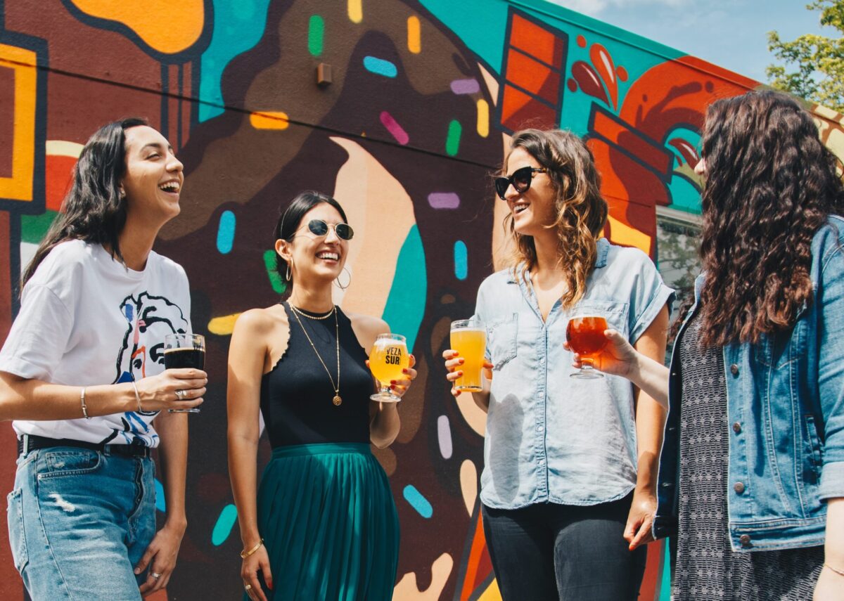 Young people talking in front of local mural