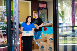 Berkshire Hathaway HomeServices Florida Properties Group employees volunteering in the 2021 Cabernet Sleigh food & toy drive